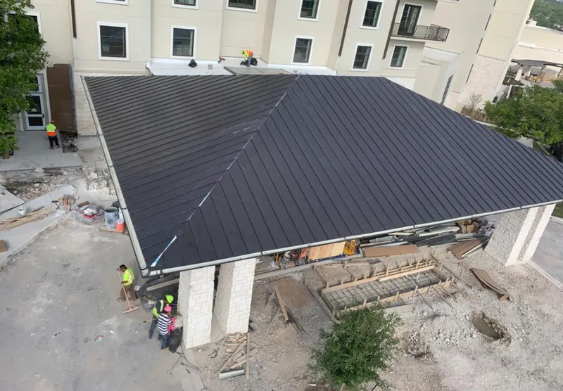 Metal roofing installation team working on a commercial building in Gustine